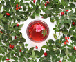 Cup of rosehip tea on background with fresh leaves and berries. Top view.  Glass mug of healthy tea with rose hips, leaves and flower. Herbal tea from  fruits of Rosa Canina.