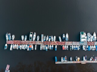 Sticker - Aerial view of boats in the water next to an old metal dock in daylight