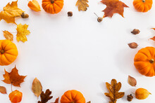 Pumpkins With Fall Leaves Over White Background. Top View.