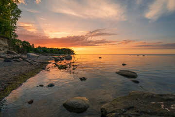 Wall Mural - Wonderful orange sunset on the rocky coast of the sea