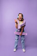 © Look! - Cheerful young caucasian girl with skateboard, headphones wear casual clothes posing in studio. Blonde opens mouth, winks, shows victory hand. Leisure lifestyle and beauty concept.