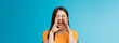 Carefree asian enthusiastic girl shouting long distance, calling friend, breaking free emotions, yelling out loud, hold hands near opene mouth rupor, searching someone in crowd, blue background