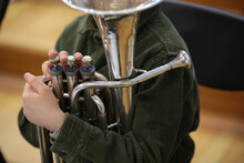 Brass Musical Instrument Tuba Is Held By A Boy With His Hand And Fingers On The Valve Close-up