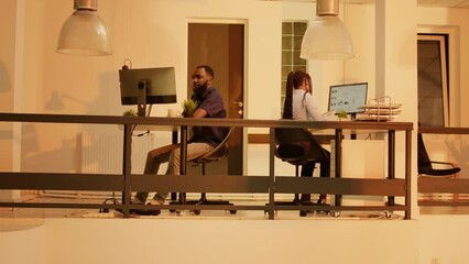 Poster - Business people working on computer in company office, using online network to create report and presentation with research data. Analyzing project notes with paperwork. Tripod shot.