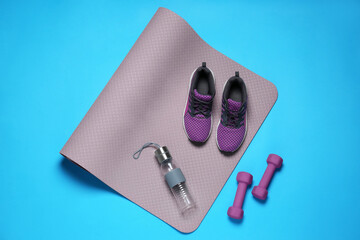 Poster - Exercise mat, dumbbells, bottle of water and shoes on turquoise background, flat lay