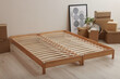 © New Africa - Wooden bed frame and cardboard boxes on floor in room