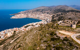 Fototapeta  - Scenic aerial view of Sarande cityscape on shores of gulf of Ionian Sea and ancient Lekuresi Castle on hill above city on sunny spring day, Albania