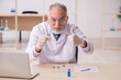 Old male chemist working in the lab during pandemic