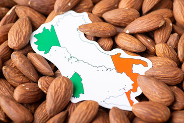 Poster - Small paper map and flag of Italy on almond nuts. Concept of growing almond in Italy, origin of almond