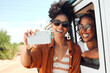 © K Abrahams/peopleimages.com - Selfie, smile and friends on a road trip with a car during a safari holiday in Kenya. African women with phone for photo, communication and social media live streaming on vacation in the desert