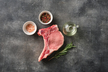 Wall Mural - Fresh  Raw pork loin with bone with salt and pepper over grey background.