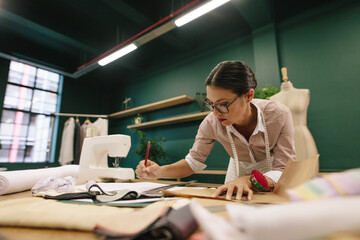 Female fashion designer drawing a design sketch in her workshop