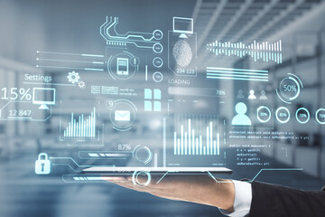 Poster - Close up of businessman hand holding tablet with creative glowing business chart interface hologram on blurry office interior background. 