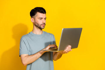 Poster - Photo of serious confident professional businessman hold new netbook typing programmer it development owner isolated on bright yellow color background