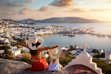 Wall Mural - a happy mother and daughter on family holidays overlook the town of mykonos island during a summer s