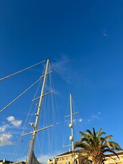 Canvas Print - Vertical shot of a boat mast in blue sky background in sunlight