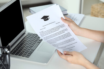 Student with acceptance letters from universities at white table indoors, closeup