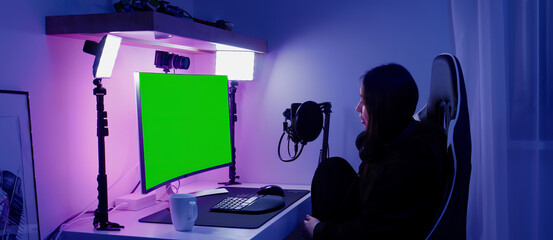 GREEN SCREEN CHORMA KEY Korean female gamer streamer putting on headphones, playing online games and streaming from home