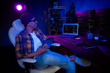 Profile portrait of happy web designer guy sit chair hold use tablet night workplace office indoors