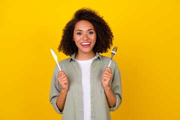 Sticker - Photo of impressed wavy young brunette lady hold knife folk wear grey shirt isolated on yellow color background