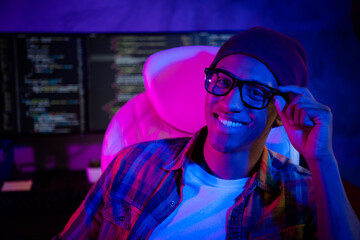 Photo of positive cheerful web designer sitting chair arm touch eyeglasses night shift workplace indoors