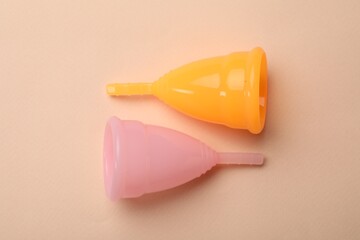 Wall Mural - Menstrual cups on beige background, flat lay