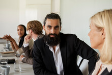 Businessman Looking At Camera During Business Meeting