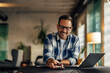 © bnenin - Happy adult businessman working at the office, using a laptop.