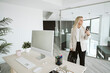 © Westend61 - Businesswoman in modern office using mobile phone
