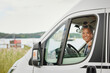 © Johnér - Portrait of smiling senior woman sitting in van