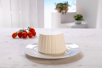 Wall Mural - ricotta cheese on white plate with tomatoes on white wooden table, set