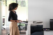 Woman in balck shirt and beige pants in the office looking determined