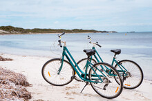 Two Bicycles Parked On A Beach On Rottnest Island, Western Australia. Bike Rental For Tourists. Scenic View