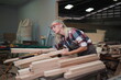 © FotoArtist - Contemporary Carpenter Working, Portrait of modern carpenter making wood furniture while working in joinery lit by sunlight with factory background on small business concept, copy space