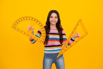 Poster - Measuring school equipment. Schoolgirl holding measure for geometry lesson, isolated on yellow background. Student study math. Happy teenager, positive and smiling emotions of school girl.