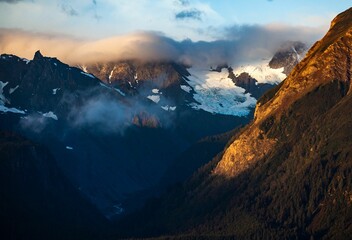 Poster - Scenic view of high mountains with snow-covered peaks under the cloudy sky