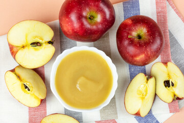 Applesauce in a white bowl, red ripe apples close-up. Healthy lifestyle, recipe, sauce, mousse, baby food, ingredients.