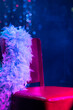 A red leather chair, a ribbon with boa feathers and a blue background with smoke before performing in the theater. A place for naked female bodies cabaret and burlesque.