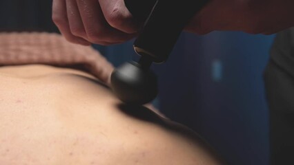 Canvas Print - Close-up slow motion percussion shock wave massage using an electric massager. Massage the lower back of a male athlete in a professional massage room