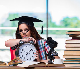 Wall Mural - Young girl preparing for exams with large clock