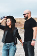 © Striker777 - Portrait of happy    smiling  Couple standing on cliff against sea during  the winter .Young happy Bearded muscular  man  kissing and hugging beautiful woman  in leather jacket and hat on a beach