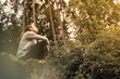 © kieferpix - woman in the forest feeling happy looking up to the trees feeling at peace in nature