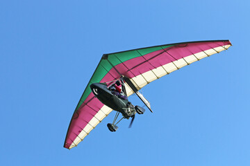 Poster - Ultralight airplane flying in a blue sky	