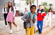 © JackF - Portrait of African american tweenager walking outside school building on autumn day, going to lessons.