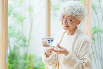 Wall Mural - リビングでお茶を飲むシニア女性