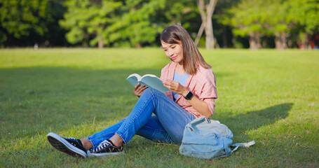 Canvas Print - asian woman reading on lawn