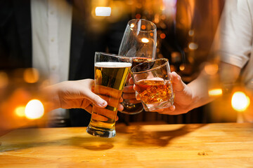 Wall Mural - food and drink male friends are happy drinking beer and clinking glasses at a bar or pub.