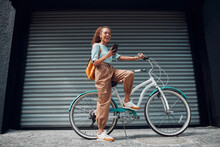 Bicycle, Woman And Phone In City Feeling Excited And Happy About Message While Outdoor In Summer With Trendy Look. Eco Friendly Transportation For Carbon Footprint Female On A Bike Using 5g Network