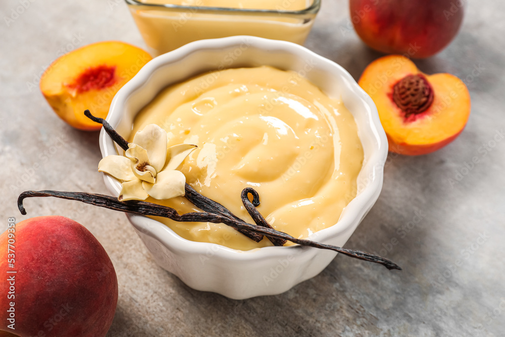 Ramekin with delicious vanilla pudding and peaches on grunge background, closeup