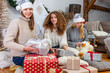 © ako-photography - young girls having fun wrapping gifts at home, great teamwork of friends packing presents for christmas